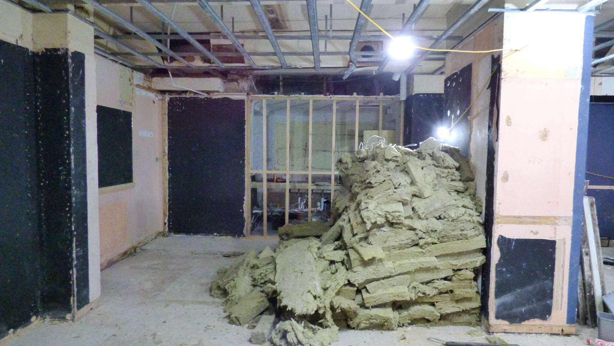 Former club interior at 74 Allitsen Road with insulation debris and exposed ceiling