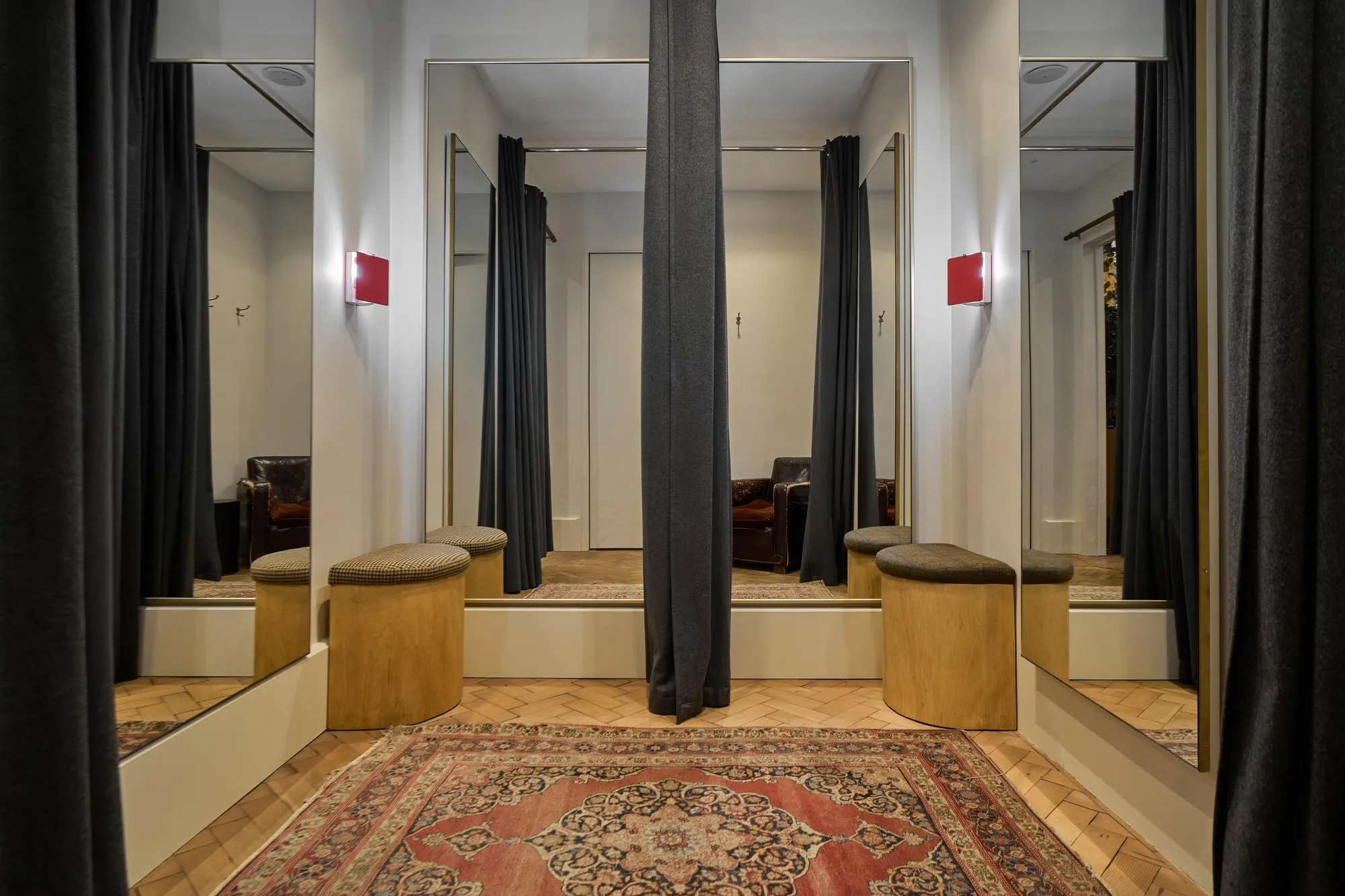 Row of made-to-order fitting rooms with curtains, mirrors and timber stools