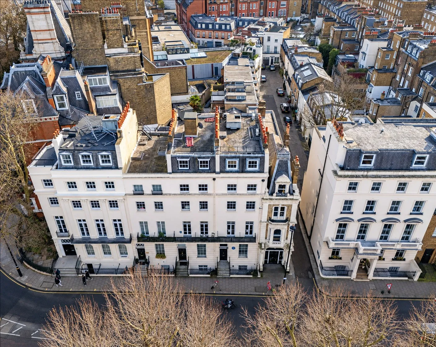 Drone view of a white stucco terrace and its roofs on Hobart Place in Belgravia