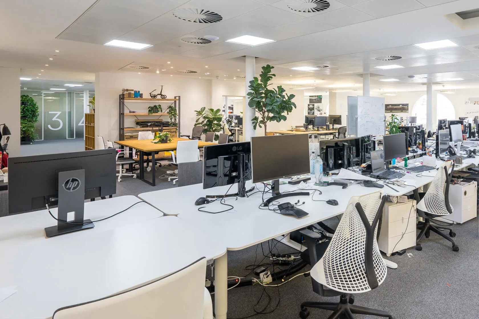 Rows of desks with monitors and task chairs in the open-plan office at Beaumont House, Kensington