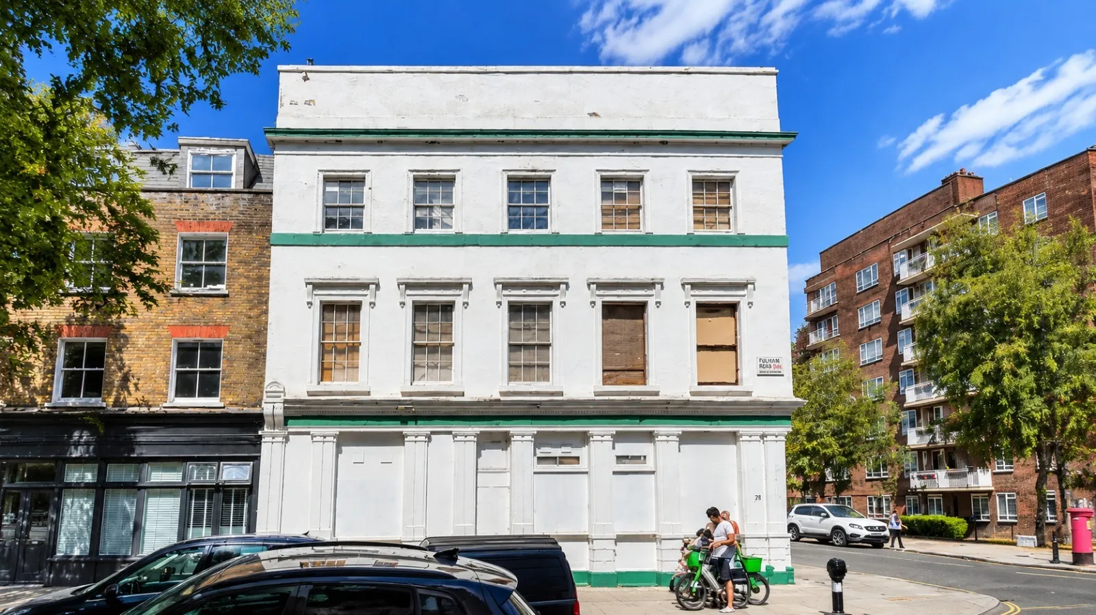 White former pub on a corner in St John's Wood with boarded windows, assessed for conversion into apartments