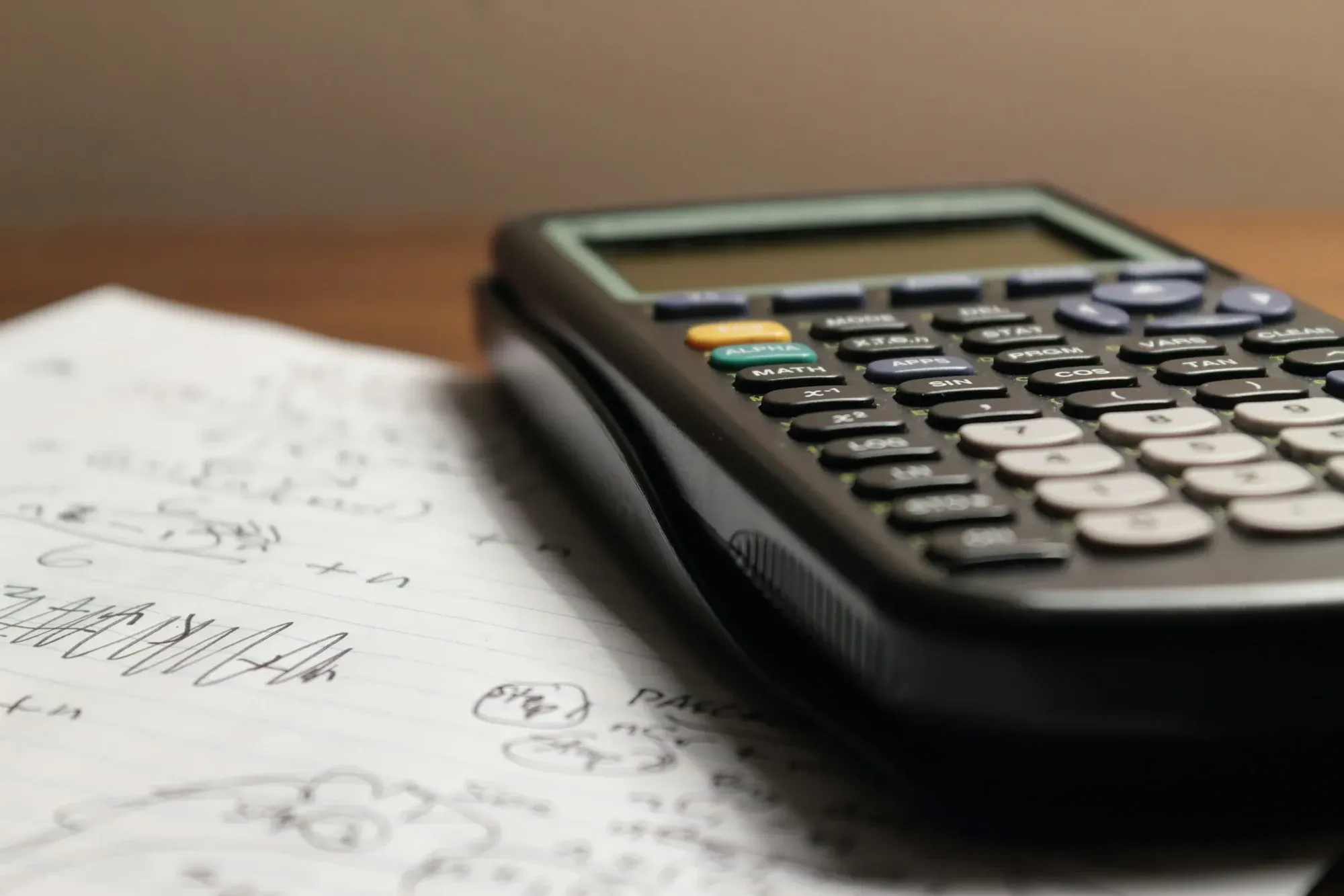 Calculator lying on a sheet of handwritten workings