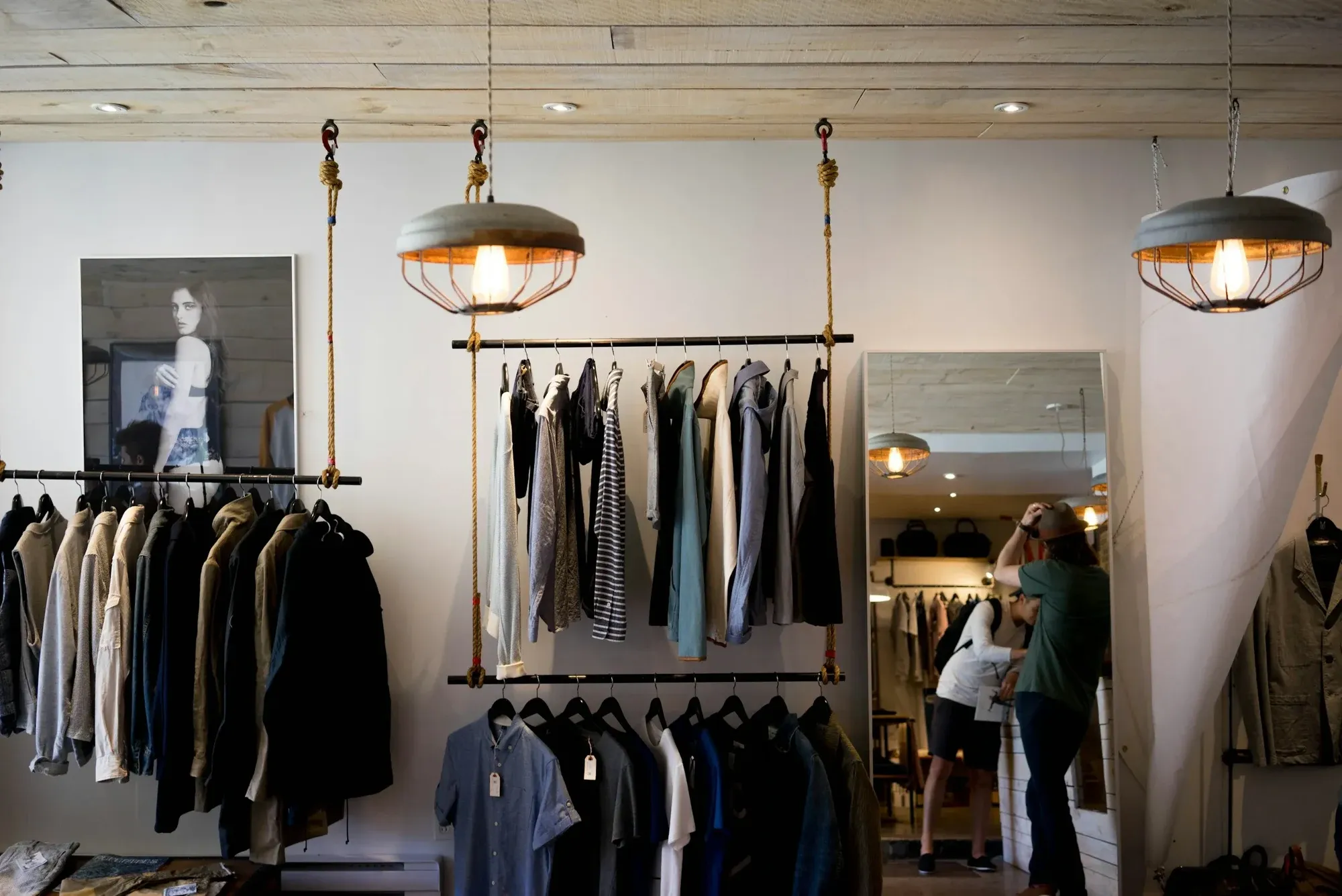 Clothing shop interior with hanging rails, pendant lights and a timber ceiling