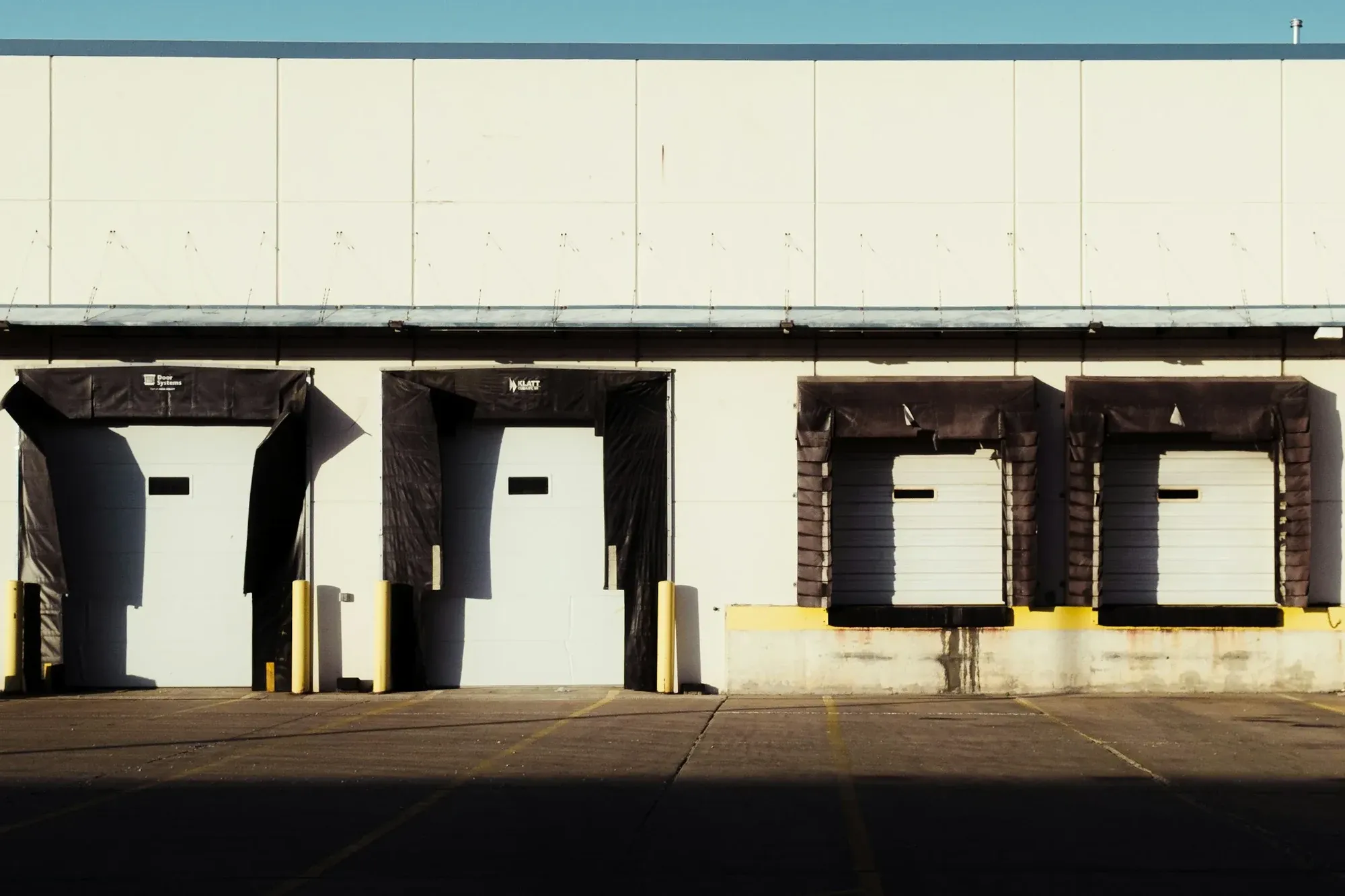 Row of loading dock doors with dock shelters on a large warehouse building